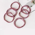 Detail view of pink elastic hair bands with matte cylindrical fastener in a flat lay set - Rose Red