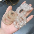 Primo piano di elastici per capelli a spirale con dettaglio di perla tenuti in mano - Corda per Capelli a Filo di Telefono a Spirale / Tre Stili Misti