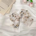 Close-up of floral chiffon bow hair clip on elegant white satin fabric with tulips - White