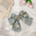 Vue détaillée d'une grande pince à cheveux nœud en mousseline florale bleu-vert clair - Bleu