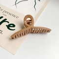 Dettaglio di un grande mollettone color caramello con finitura lucida e molla in metallo - Cachi