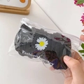 Close-up of black daisy hair claw clip in a transparent slide zipper retail packaging - Daisy Black Style (B-163) / Black