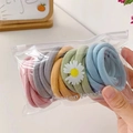 Close-up of rainbow elastic hair bands in a clear pouch with a daisy flower charm - Bean Paste Mix
