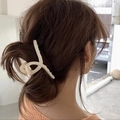 Pince à cheveux croisée beige mat et boucles d'oreilles créoles dorées sur le modèle - Beige