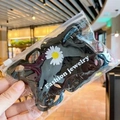 Close-up of black wavy matte hair clips in daisy print zipper bag packaging - 50 PCS Set / Black