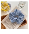 Gros plan d'un chouchou bleu à fleurs avec marguerites blanches sur papier vintage - Motif floral