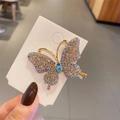 Dettaglio del fermaglio per capelli a farfalla con strass colorati su base dorata - Oro
