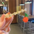 Close-up of handmade beaded hair clip with crystal beads and red rose charm on gold metal - Orange Spring Clip