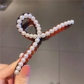 Détail d'une grande pince à cheveux ambre ornée de perles blanches élégantes - Ambre