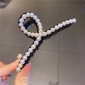Dettaglio di una grande molletta nera per capelli con eleganti perle bianche - Nero