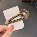 Dettaglio di un fermaglio per capelli a catena d'oro vintage con margherita e perla - Fiore di Margherita