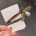 Detail shot of vintage bee hair clip with pearl body and sparkling rhinestone wings - Bee