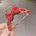Detail of elegant gold metal chain hair claw with red ribbon and bow tie decoration - Red