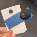 Dettaglio del fermaglio in denim blu con perla nera opaca e decorazione in strass - Stile Perla Nera