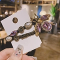 Detail of vintage gold bee hair clip with purple crystal and teardrop pearl on card - Purple