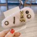 Détail d'une pince à cheveux rose en peluche avec lapin doré, lettrage Loveme et perles - Rose