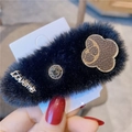 Détail d'une barrette à cheveux en peluche noire avec texte doré et motif monogramme - Noir