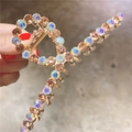 Gros plan sur une grande pince à cheveux dorée ornée de strass étincelants - Champagne