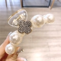 Vue détaillée de la pince à cheveux camélia avec perles et décor de trèfle en cristal - Fer à Cheval Trèfle Blanc