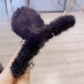 Close-up of a large black faux fur claw clip for women's elegant winter hairstyling - Black