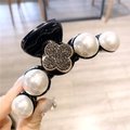 Détail de grandes perles blanches et trèfle en strass gris foncé sur une pince à cheveux - Trèfle Noir