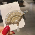Dettaglio di un fermaglio a ventaglio con perle, strass e finitura in lega dorata - Stile Forma a Ventaglio