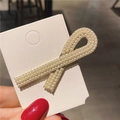 Vue macro d'une élégante pince à cheveux en perles avec base en alliage doré chic - Note de Musique Perle
