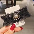 Dettaglio di un fermaglio vintage in pizzo nero con grande perla centrale e strass brillanti - Perla Girasole in Pizzo