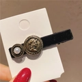 Dettaglio di fermaglio per capelli vintage in velluto nero con perla e moneta in bronzo - Semplice Becco di Corvo