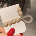 Dettaglio del fermaglio per capelli dorato con perle eleganti e strass scintillanti - Nota Musicale Dorata