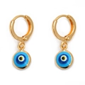 Macro view of gold hoop earrings with multi-colored blue Evil Eye pendant charms - Yellow & Blue