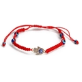 Detail of red woven bracelet featuring a sparkling Hamsa hand and blue evil eye charms - Hamsa Hand Pendant Style (BE520RD01)