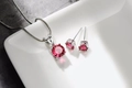 Detailansicht der rosa Zirkonia-Halskette und Ohrringe auf einem Keramiktablett - Roter Zirkon