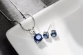 Dettaglio della parure collana e orecchini in zircone blu zaffiro su piatto bianco - Strass Blu