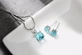 Dettaglio del set collana e orecchini con zircone blu su vassoio di ceramica bianca - blu mare
