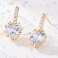 Détails macro de boucles d'oreilles cœur dorées avec incrustation de zircon blanc - Or/Blanc