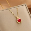 Detail van gouden ketting met rode zirkoon hanger en fonkelende witte micro-steentjes erop - Goud Rood