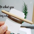 Gros plan d'une barrette à cheveux kaki brillante sur une carte de marque - Beige