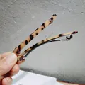 Primer plano de horquilla con patrón de carey y base de resorte de metal plateado - Leopardo Beige