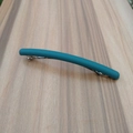 Detail shot of a matte cyan curved spring hair clip with a silver metal mechanism base - Lake Blue