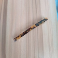 Détail d'une barrette à motif léopard en résine polie avec pince à ressort métallique - Léopard Foncé