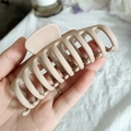 Grosse pince à cheveux beige mat avec un design évidé durable en gros plan - Beige Café