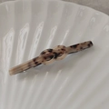Makroaufnahme der Haarklammer aus Acetat mit Schildpattmuster und Knotendesign auf Schale - Heller Leopard