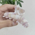 Dettaglio di una grande pinza per capelli in acetato con trama marmorea lilla - Stile Viola Floreale