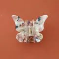 Détail de la pince à cheveux papillon avec motif marbré et ressort en métal doré - Rose chair
