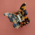 Gros plan sur la pince à cheveux papillon en écaille de tortue avec ressort en métal - Couleur Foncée