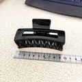 Detail view of large black square hair claw clip measuring 8.5cm with ruler reference - Black