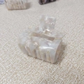 Macro detail of elegant ivory marble hair claw clip with a polished finish - Fresh Floral Pattern