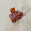 Primer plano de pinza para el cabello cuadrada de ámbar con acabado muy brillante - Marrón