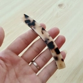 Dettaglio del fermaglio per capelli a banana in acetato con motivo maculato tartarugato - Leopardo Chiaro